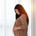 Indian-woman-during-pregnancy-gently-holding-her-baby-bump,-symbolising-successful-fertility-outcomes-and-PCOS-management